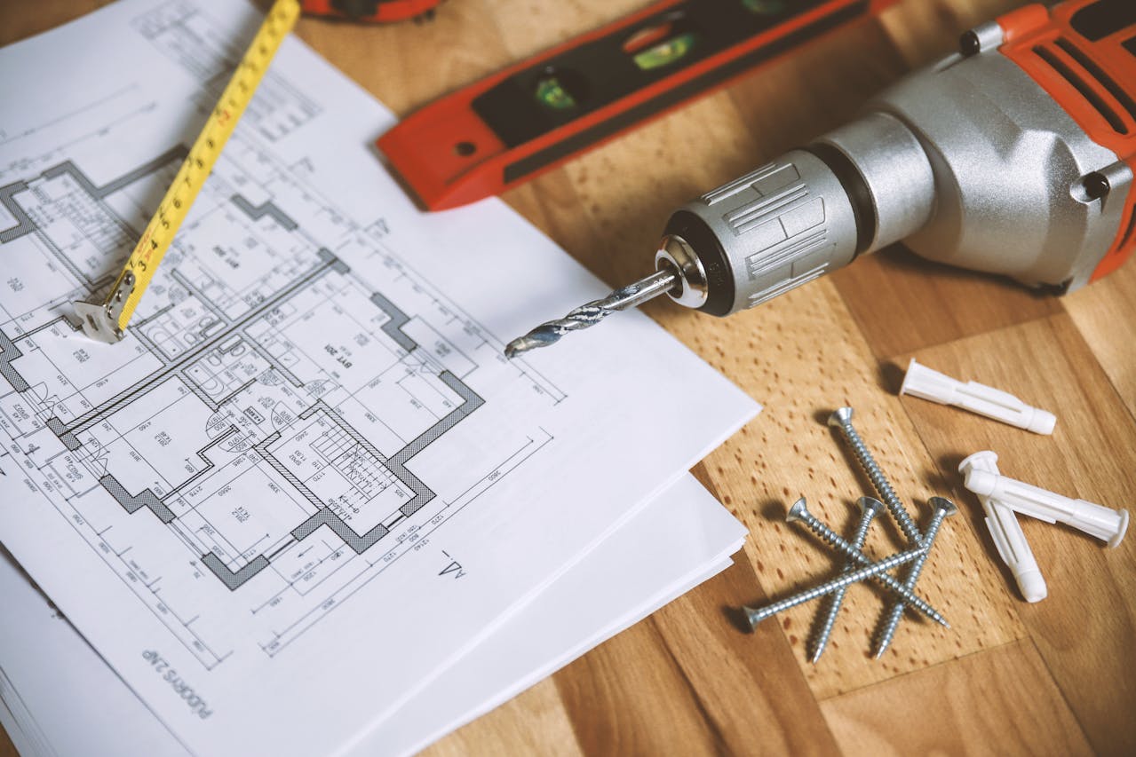 screwdriver with nails and home building plans